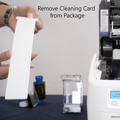 Person holding a white cleaning card with text 'Remove Cleaning Card from Package' above a printer.