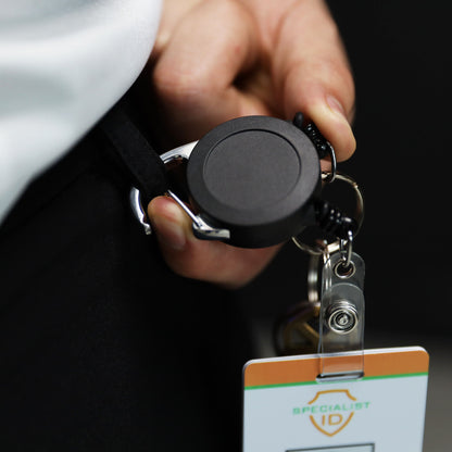 Close-up of the carabiner clipping onto a belt loop, with a badge and keys attached