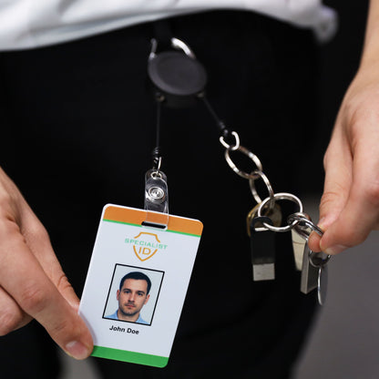 Person holding the dual retractable badge reel with an ID badge attached