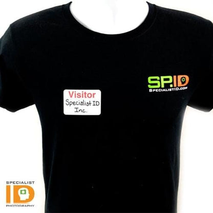 Person wearing a black t-shirt with "SPID" logo on the front and a name tag reading "Visitor, Specialist ID Inc.," showcasing effective visitor management with an Expiring TIMEbadge Adhesive Backpart, Box of 1000 (P/N T6032A).