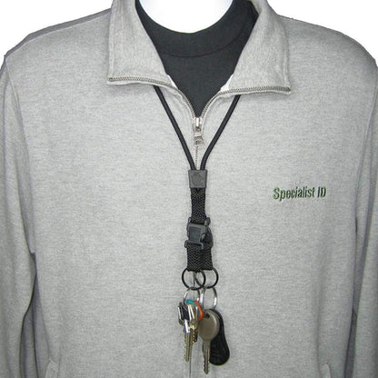 Person wearing a gray zip-up jacket with an EK Black Lanyard With Two Detachable Key Rings (10046) by EK USA holding multiple keys clipped to it. The jacket has "Specialist ID" embroidered on the left side.