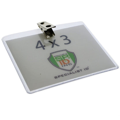 A 4x3 Inch Clear Vinyl Horizontal Badge Holder with Clip (1810-1300) with the dimensions "4 x 3" and the logo of "Specialist ID" visible in the center. It features a 2-hole clip for secure attachment at the top and is designed in a top load government/military size.