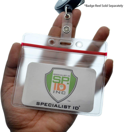 Hand holding a Heavy Duty Clear Vinyl Horizontal Badge Holder With Resealable Zip Top (1815-1010) with a Specialist ID company card inside. The badge holder features a red resealable zip top and a metal clip at the top. Text reads "Badge Reel Sold Separately.
