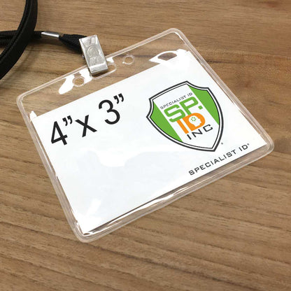 A 4 x 3 inch Clear PureClear Horizontal 4X3 Badge Holder (P/N 1815-1125) with an attached lanyard, displaying a logo for Specialist ID Inc. on a wooden surface.