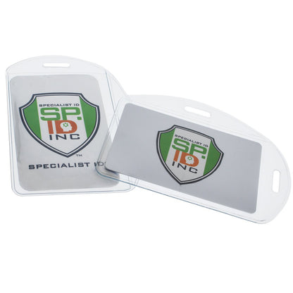 Two clear plastic ID card holders with the Specialist ID, Inc. logo—one upright and the other lying flat in front. These **Vertical / Horizontal Durable Clear Vinyl ID Badge Holders (1815-1600)** each have a slot for attaching to a lanyard, making them perfect for a professional workplace environment.