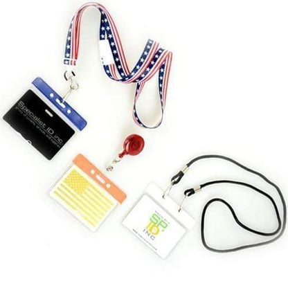 Three lanyards with ID badges: one has a blue clip, another features a retractable clip with a U.S. flag motif, and the third has a black lanyard. Each ID card holder is attached to a Horizontal Vinyl Badge Holder with Color Bar Top - Great for Color Coding Access and ID (1820-100X).