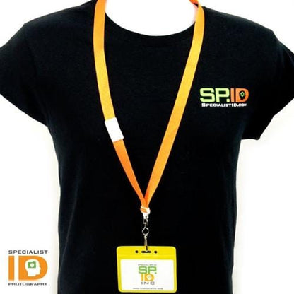 A person wearing a black shirt with the "Specialist ID" logo and an orange lanyard holding a yellow, Horizontal Vinyl Color-Back Badge Holder (P/N 1820-200X). The shirt and badge feature the text "Specialist ID," ensuring quick identification.