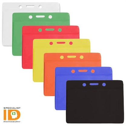 A set of six Horizontal Vinyl Color-Back Badge Holders (P/N 1820-200X) arranged in a staggered order, featuring white, green, red, yellow, orange, and blue for quick identification. Each holder has a logo in the bottom left corner—perfect for student bus assignments.