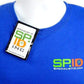 Close-up of a blue t-shirt with the logo "SP.ID SpecialistID.com" on the chest, featuring an ID badge in a Magnetic Vertical Double Pocket Badge Holder (1835-1115) attached near the collar.