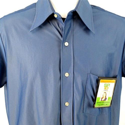 A blue collared shirt with white buttons. A Magnetic Badge Holder for Shirt Pocket or Belt - Vertical Fold Over Single Card Holder (1835-1150) with a person's photo and text is neatly placed in the shirt's front pocket.