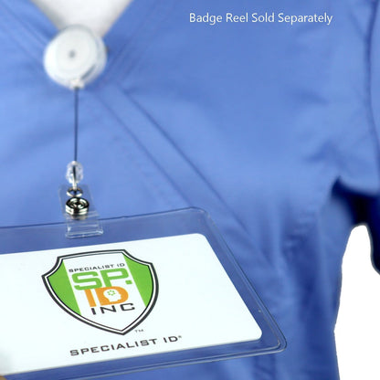 A person wearing a blue scrub top with a Clear Heavy Duty Vinyl Horizontal Proximity Card Holder 1840-5017 holding an ID card displaying the Specialist ID Inc logo. Text on the image reads "Badge Reel Sold Separately.