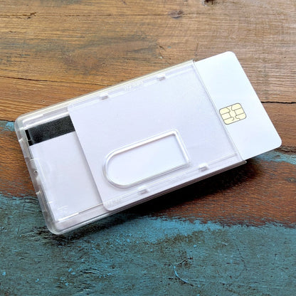 A SIM card ejection tool and a SIM card partially inserted in a clear plastic holder, alongside a Frosted Vertical Rigid 2-Card Access Card Dispenser (1840-6550), placed on a wooden surface.