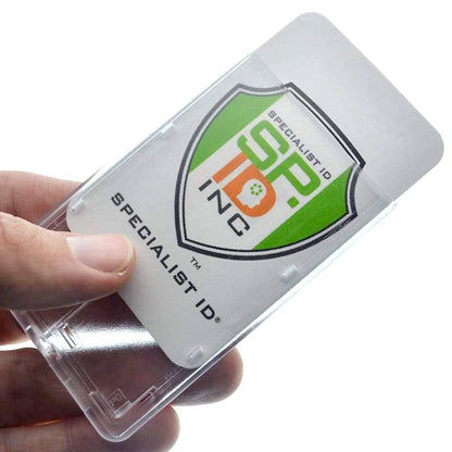 A hand holding a Frosted Vertical Rigid ID Badge Holder with Red Extractor Slide (P/N 1840-6566) with a standard credit card sized ID badge inside. The card displays a logo with the text "Specialist ID SP ID Inc.
