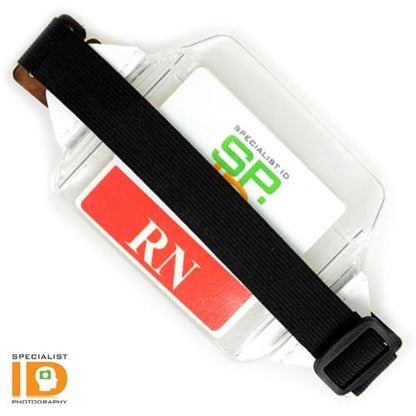 A Clear Over Size Vinyl Horizontal Arm Band Badge Holder (P/N 1840-7100) with a black strap securing a card labeled "RN" and another partially visible card. The "Specialist ID" logo is in the lower left corner.