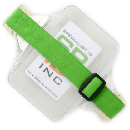 A transparent heavy-duty Oversize Vertical Armband Badge Holder (1840-7110) with a green elastic strap and plastic buckle. The visible ID card inside reads "Specialist ID.