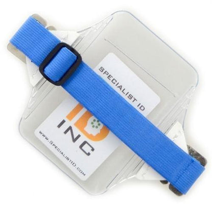 Clear **Oversize Vertical Armband Badge Holder (1840-7110)** with a blue adjustable elastic strap and a visible ID card inside, labeled "ID Inc." Made from heavy-duty vinyl, the design ensures durability and protection.