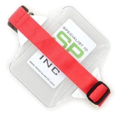 A heavy-duty vinyl clear Oversize Vertical Armband Badge Holder (1840-7110) with a red adjustable strap, containing a Specialist ID Inc card.