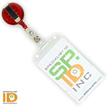 A clear, rigid Vertical Open Face Plastic ID Holder (1840-816X) with a green and orange "Specialist ID Inc" logo card inside is attached to a red retractable badge reel. The Specialist ID logos are visible on both the card and bottom left corner of the vertical plastic card holder.