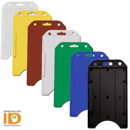 Six differently colored Vertical Open Face Plastic ID Holder (1840-816X), featuring a rigid plastic design, are arranged in a staggered fashion. The colors from left to right are white, yellow, brown, green, blue, and black. The Specialist ID logo is visible on each Vertical Open Face Plastic ID Holder (1840-816X).