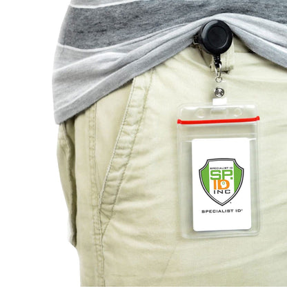 A person wearing light-colored pants has a Badge Reel with Swivel Spring Clip (P/N 2120-760X) clipped to their waistband. The retractable reel holds a card with a logo and the text "Specialist ID Inc.