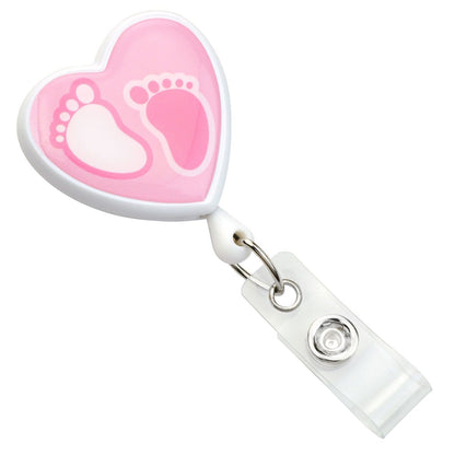 This Custom Heart Shaped Badge Reel With Rotating Spring Clip - Personalize with Your Logo features a charming pink and white baby footprints design and includes a transparent clip, perfect for promoting brand awareness with a personalized touch.