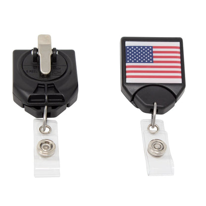 Two retractable badge holders: one with a plain black belt clip, and one with a USA Patriotic Flag B-Reel with Swivel Clip (P/N 2120-7653). Both have clear plastic straps with metal snaps.