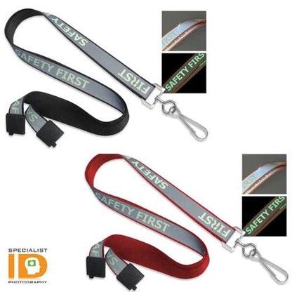 The image features two "Safety First" Reflective Lanyard With Luminescent Glow in the Dark Print 2135-251X: one black and one red, both with reflective text. Inset images showcase the reflective properties in low light, enhancing visibility. These Safety First lanyards prioritize your safety by ensuring high visibility in various conditions.