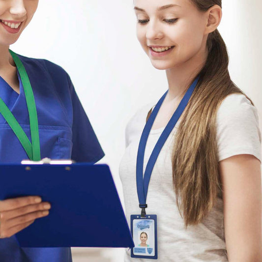 Two women, one in medical scrubs holding a clipboard and the other in casual attire, both wearing Antimicrobial Lanyard with Breakaway Clasp and No Twist Plastic Hook - 5/8" Wide (2136-340X) with ID badges, stand together and smile.