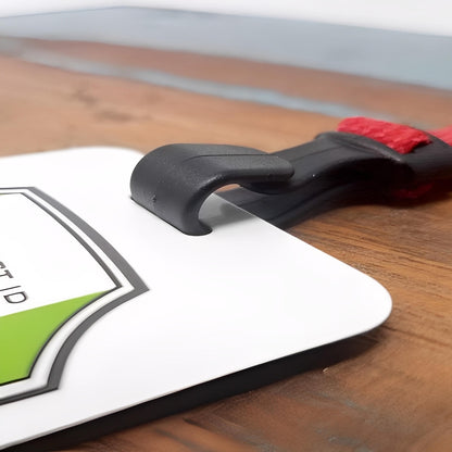 Close-up of the Breakaway Lanyard with No Twist Plastic ID Clip (2137-474X), MRI and metal detector friendly, showing its black plastic hook attached to a white badge with a green and black design—no metal parts.