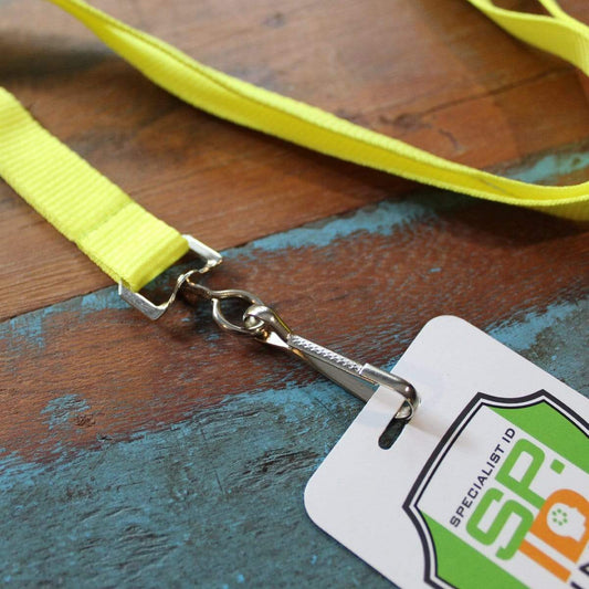 A Neon Lanyard with Safety Breakaway Clasp - High Visibility Bright Soft Lanyards (2138-504X) with a metal swivel hook attachment and a plastic ID card holder, labeled "Specialist ID," lies on a blue, distressed wooden surface.
