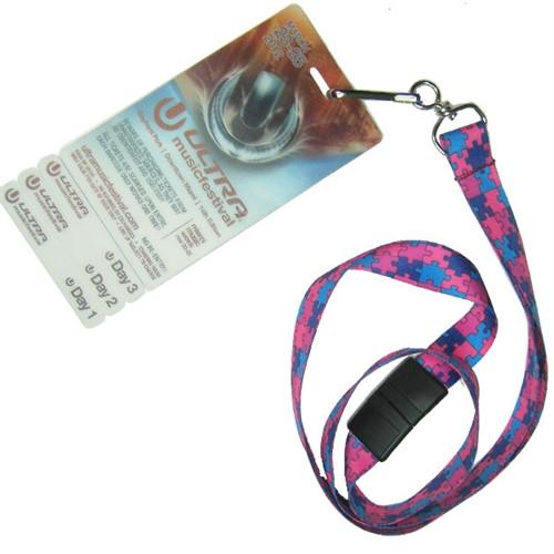 A festival pass attached to an Autism Awareness Flat Breakaway Lanyard With Swivel Hook (2138-5281, 2138-5282) with a pink and blue puzzle piece pattern. The pass features days listed as "Day 1," "Day 2," and "Day 3," and the lanyard comes with a convenient breakaway feature.