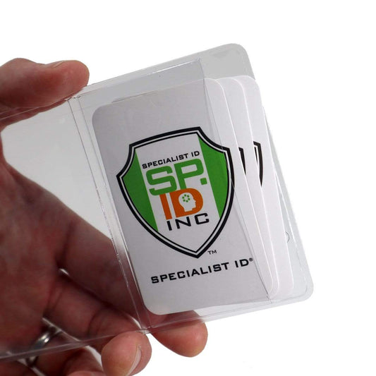 A hand holds a 3 5/8 x 5 Special Event Badge & Credential Badge Holder with Business Card Pocket on Back (P/N 306-2P46) containing multiple white cards, each adorned with a green and orange shield logo labeled "Specialist ID Inc." Perfect for a business card pocket or special event badge.