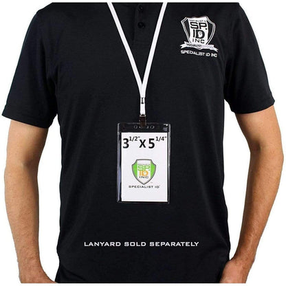 Person wearing a black shirt with a white lanyard holding an oversized 3 1/2" X 5 1/4" Clear Vertical Large Event Badge Holder (P/N 306-46) featuring the Specialist ID Inc logo. Text at the bottom states "Lanyard sold separately.