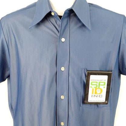 A blue button-up shirt with an Oversize Magnetic Vertical ID Badge Holder for CR100 Cards - 501-L attached to the front pocket, displaying a card labeled "SPID INC.