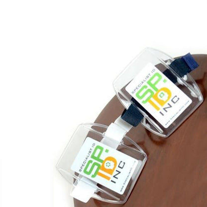 Two Government ID Size Vertical Arm Band Badge Holders with Heavy Duty Vinyl and Hook & Loop Elastic Band (504-ARFB & 504-ARFW) are displayed on a brown surface. One cardholder has a green logo with "SP-ID INC" text.