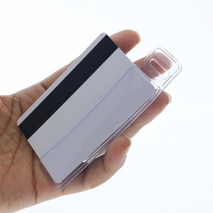 A hand holding a white plastic card with a black magnetic strip, encased in a transparent protective sleeve, resembling a Vertical Half Card Vinyl Holder with Slot (P/N 504-HC1).