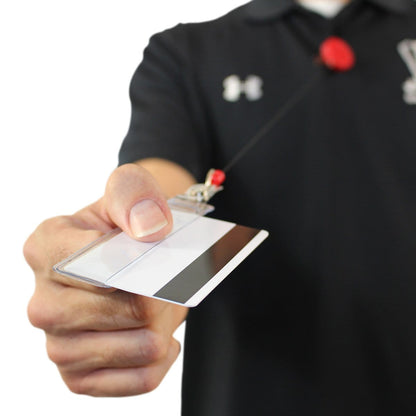 A person wearing a black shirt holds out a credit card size ID badge in a Vertical Half Card Vinyl Holder with Slot (P/N 504-HC1) attached to a retractable lanyard.