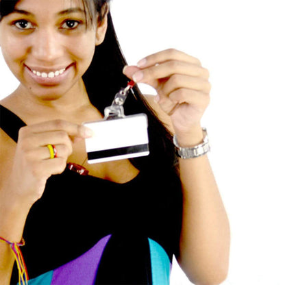 A person is smiling and holding up a Horizontal Half Card Vinyl Holder with Slot (P/N 504-HC2) attached to a lanyard. They are wearing a black sleeveless top and have a watch on their left wrist.