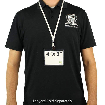 Person wearing a black polo shirt with a logo on the chest, displaying a 4 X 3 Name Badge Holders - Premium Horizontal Clear Vinyl Convention Size 4x3 Badge Holder (506-J) attached to a white lanyard around their neck. Text below reads, "Lanyard Sold Separately.