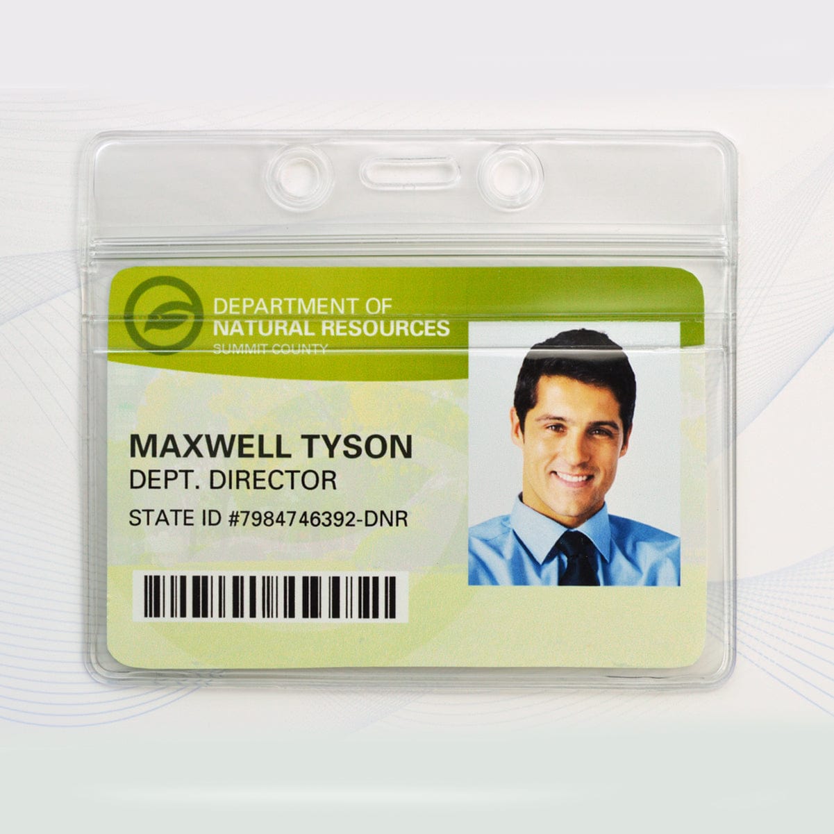 Department of Natural Resources ID badge with a photo of a man, labeled "Maxwell Tyson, Dept. Director," and including state ID number #7984746392-DNR. The badge is securely placed in a Horizontal Vinyl Badge Holder with Zipper Top (506-ZHOS-CLR) for enhanced ID card protection.