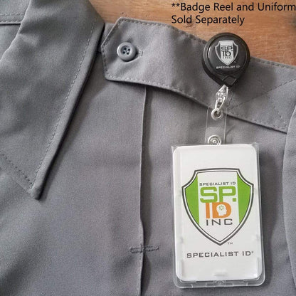 Gray uniform with a buttoned collar, featuring a badge reel holding a Premium Top Load Slim Rigid Plastic ID Badge Holder with Easy Access Thumb Slide Removal (706-N) labeled "Specialist ID" and the text "SR Inc" with a shield icon. Text indicates the badge reel and uniform are sold separately.