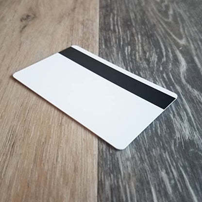 A high quality Standard CR80 30mil Card w/ HiCo Mag Stripe lies on a wooden surface. Sold by Specialist ID.