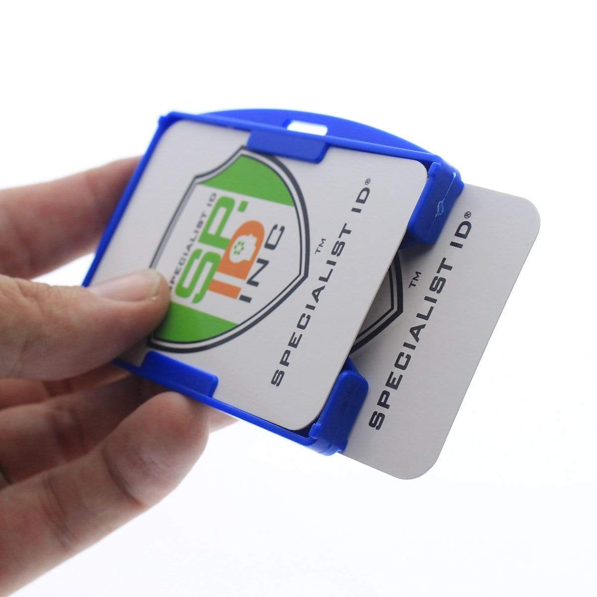 A hand holds a Two Card Holder - Rigid Open-Faced (P/N AH-150) with two Specialist ID cards inserted.