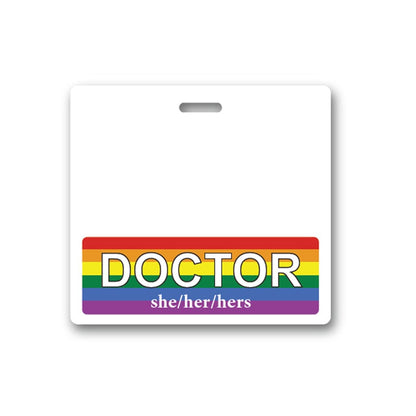 A white badge with a rainbow stripe at the bottom. The stripe proudly displays "DOCTOR" in large font and "she/her/hers" beneath it in smaller font. This DOCTOR Pronouns Badge Buddy Horizontal with Rainbow Border effectively communicates both professional title and gender pronouns, reflecting rainbow pride.