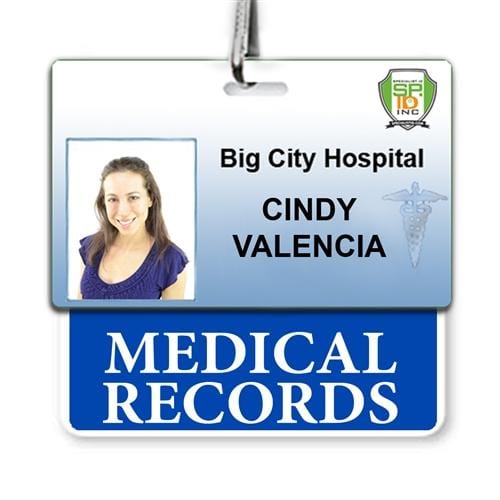 A hospital ID badge for Big City Hospital in a typical hospital setting shows the name Cindy Valencia with a photo, indicating the MEDICAL RECORDS Horizontal Badge Buddy with Blue Border department.