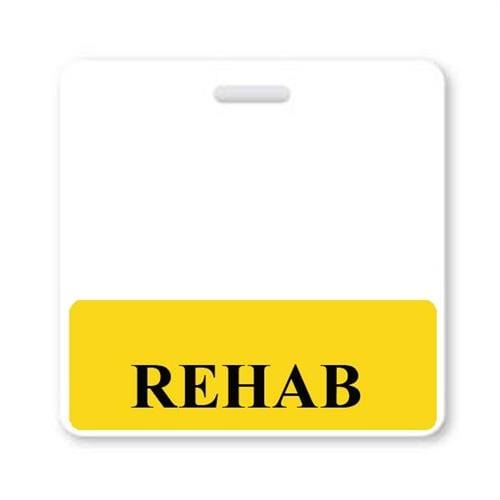 A label with a white background and a yellow area at the bottom features the word "REHAB" in black, capitalized letters, resembling a REHAB Horizontal Badge Buddy with Yellow Border often seen in a hospital setting.