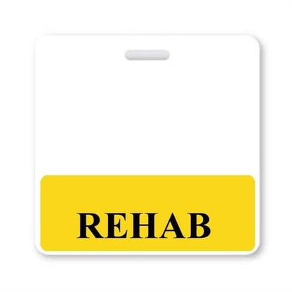 A label with a white background and a yellow area at the bottom features the word "REHAB" in black, capitalized letters, resembling a REHAB Horizontal Badge Buddy with Yellow Border often seen in a hospital setting.