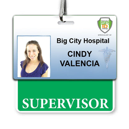 Identification badge for "Cindy Valencia" at "Big City Hospital," labeled "Supervisor," featuring a small photo of a woman in a blue top. The badge top includes a hospital insignia, and it serves as her official **Supervisor Horizontal Badge Buddy with GREEN border**.