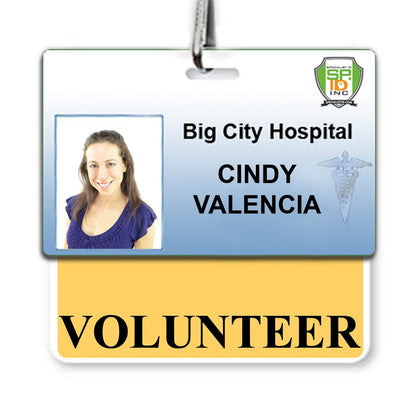 ID badge for Big City Hospital with the name Cindy Valencia, featuring a photo, a medical symbol, and a hanging strap. A yellow border frames the bottom tag where the word "Volunteer" Horizontal Badge Buddy with Yellow Border is displayed in bold letters.