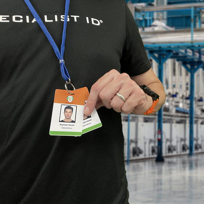 Person wearing a black shirt and blue Premium Key Ring Lanyard with Breakaway Clasp - 3/8 Inch Wide Lanyard with Split Ring Keychain (BL-34R), holding two ID cards in a factory setting.
